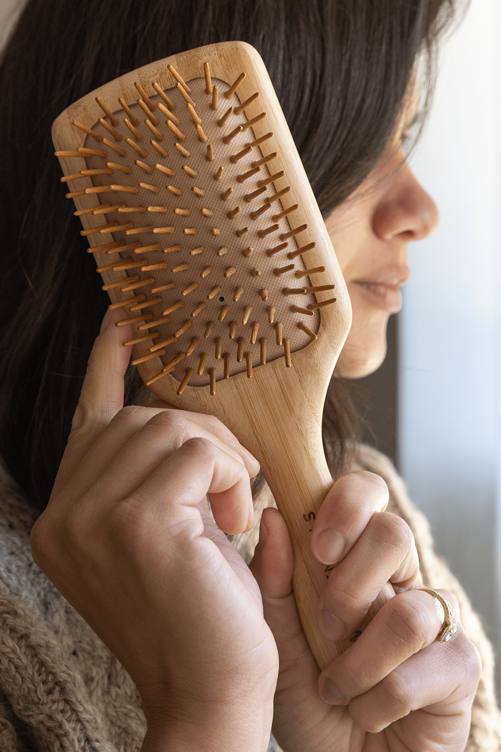bamboo hairbrush being held by model. bamboo hairbrush being held by model.