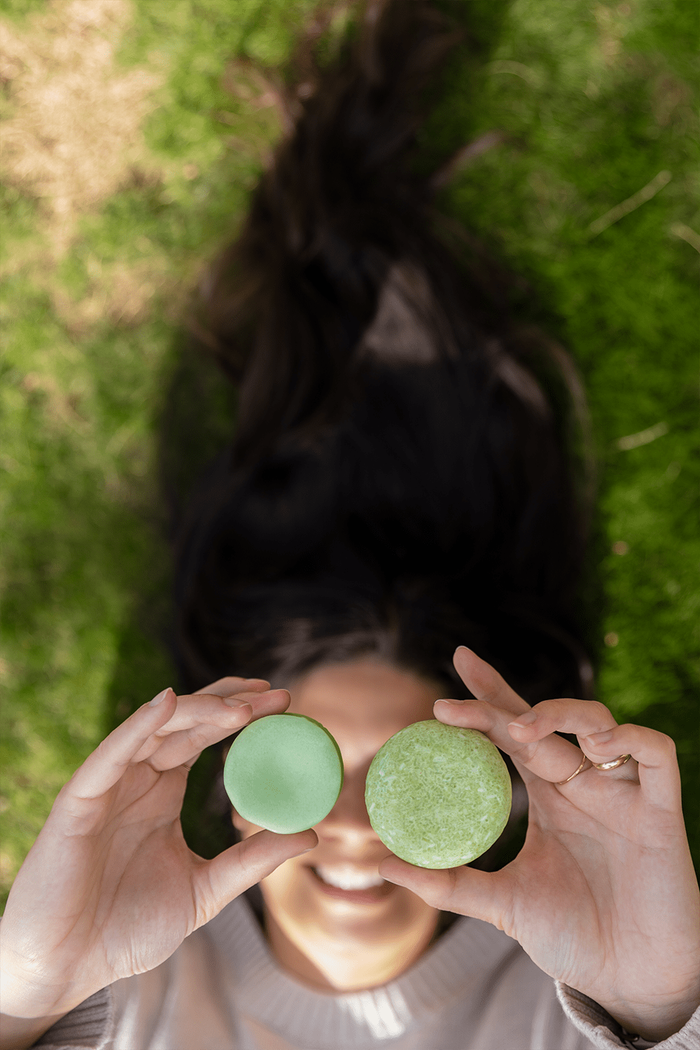 girl laying in grass with shampoo and conditioner bars girl laying in grass with shampoo and conditioner bars