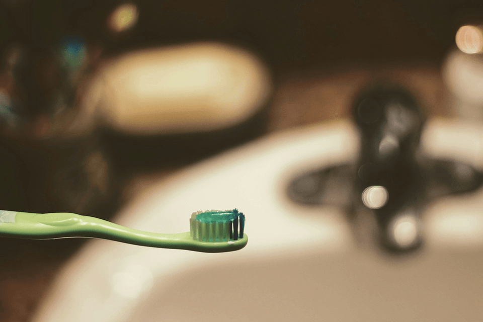 green plastic toothbrush with toothpaste