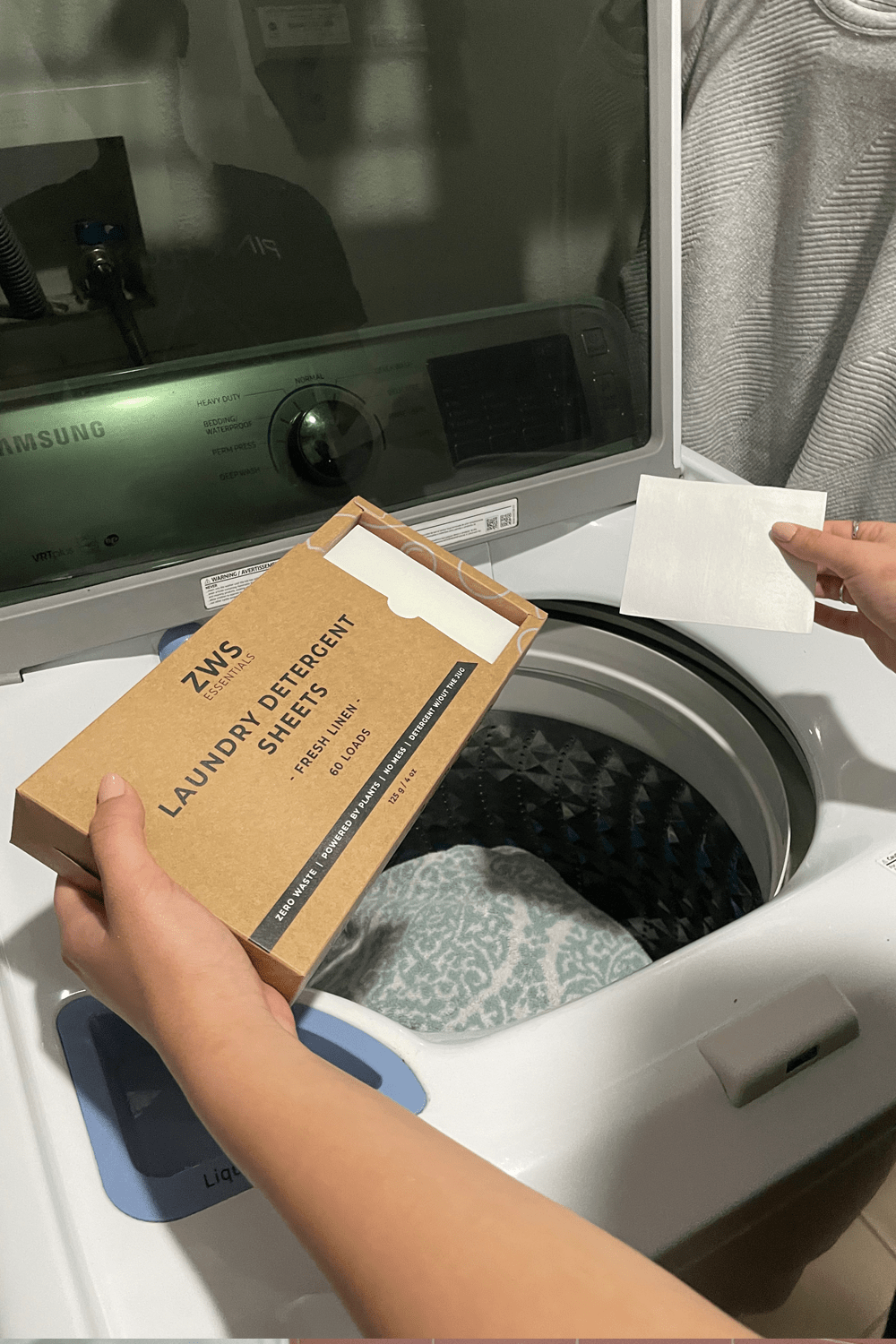 model placing laundry detergent sheets in wash