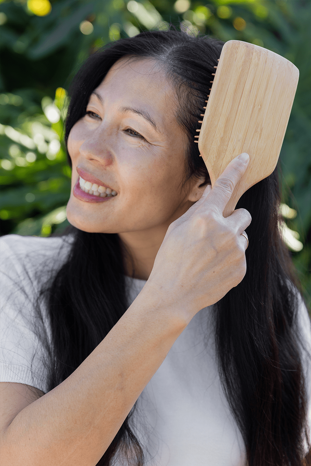 older women brushing her hair with bamboo hair brush